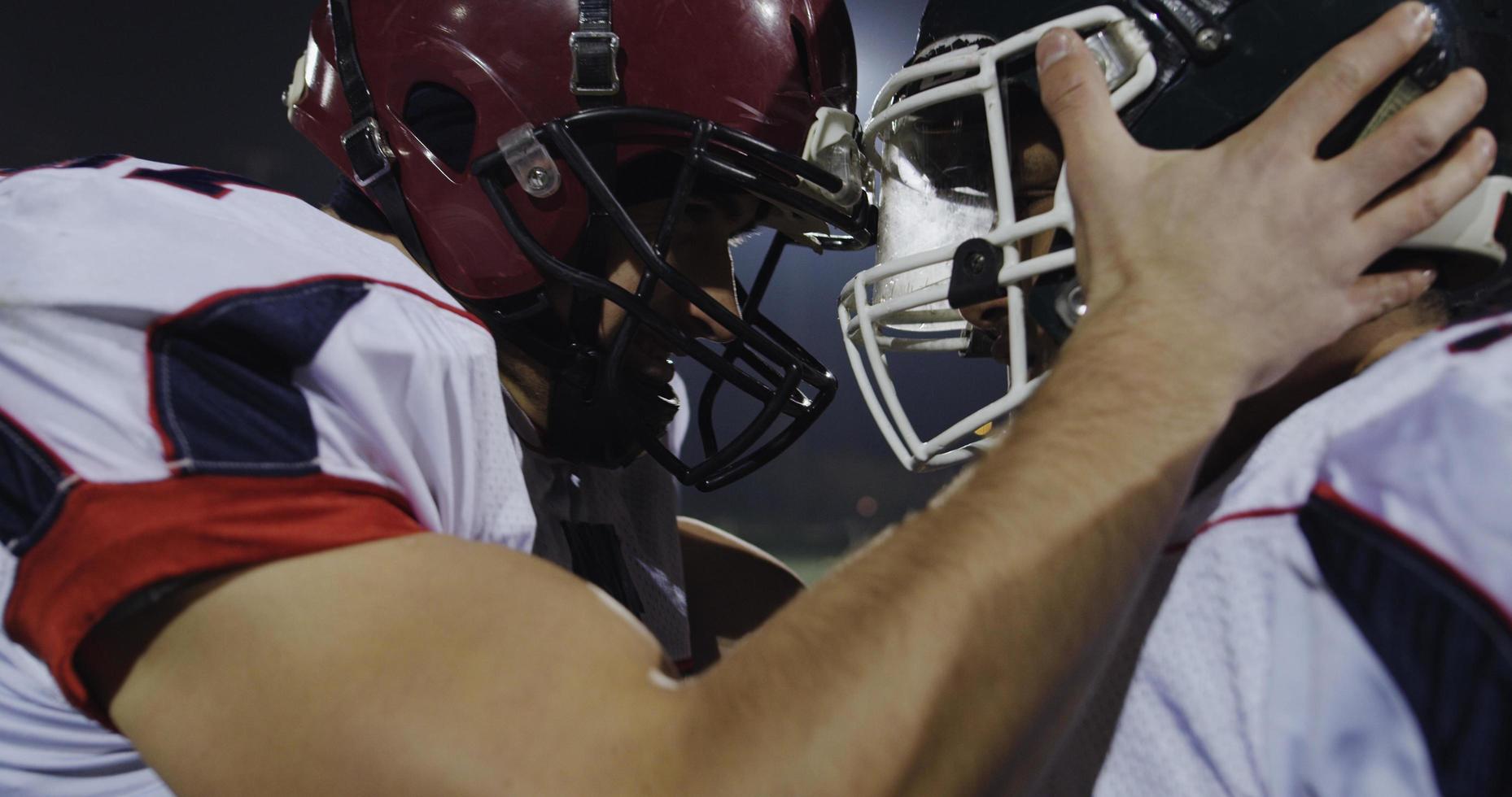 American football players knocking with helmets and having fun photo