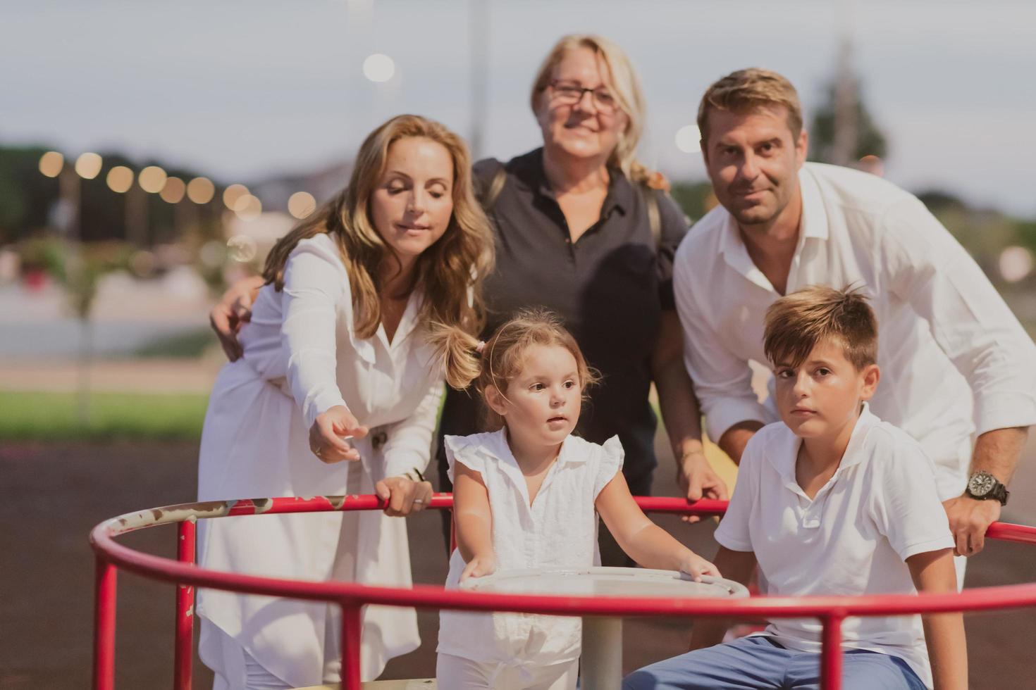 An elderly couple in casual clothes with their children and grandmother spend time together in the park on vacation. Family time. Selective focus photo