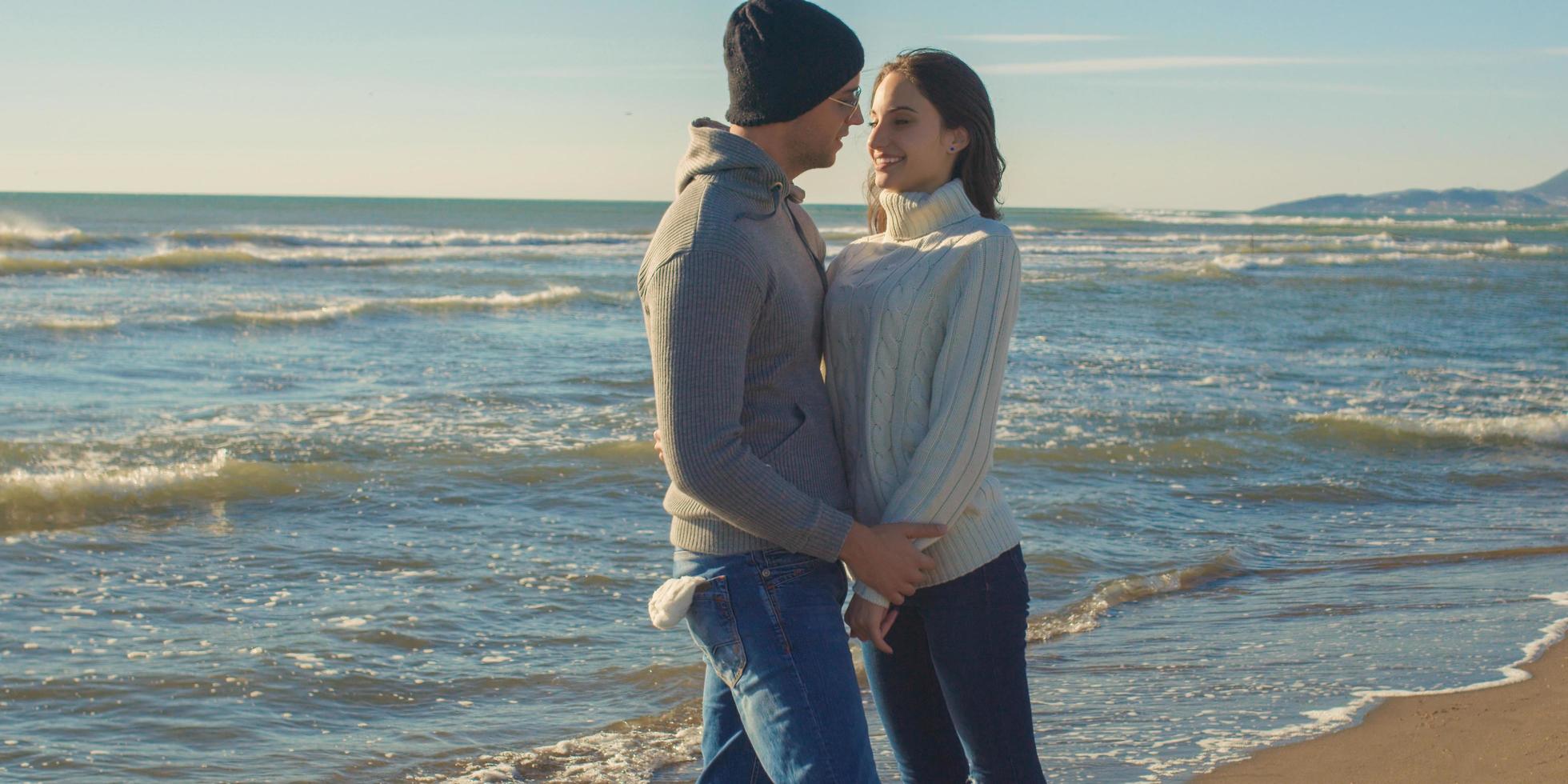 Couple having fun on beautiful autumn day at beach photo