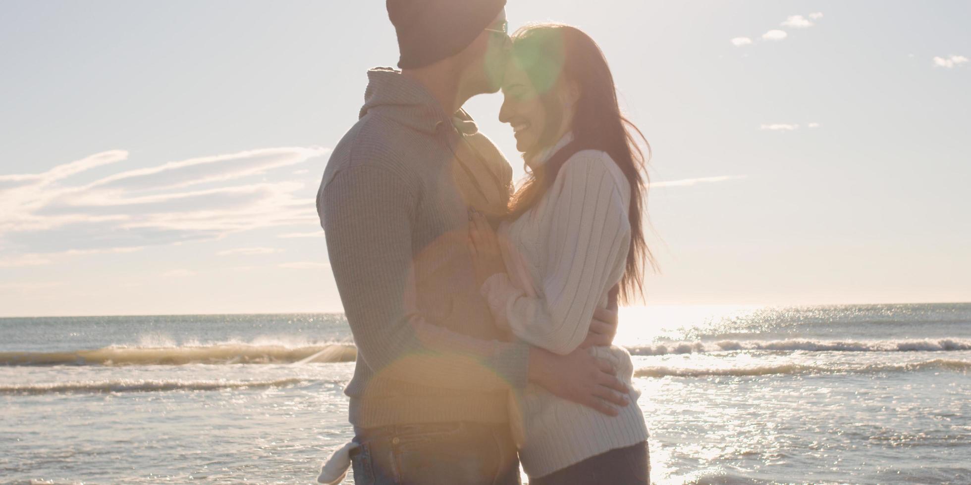 Couple having fun on beautiful autumn day at beach photo