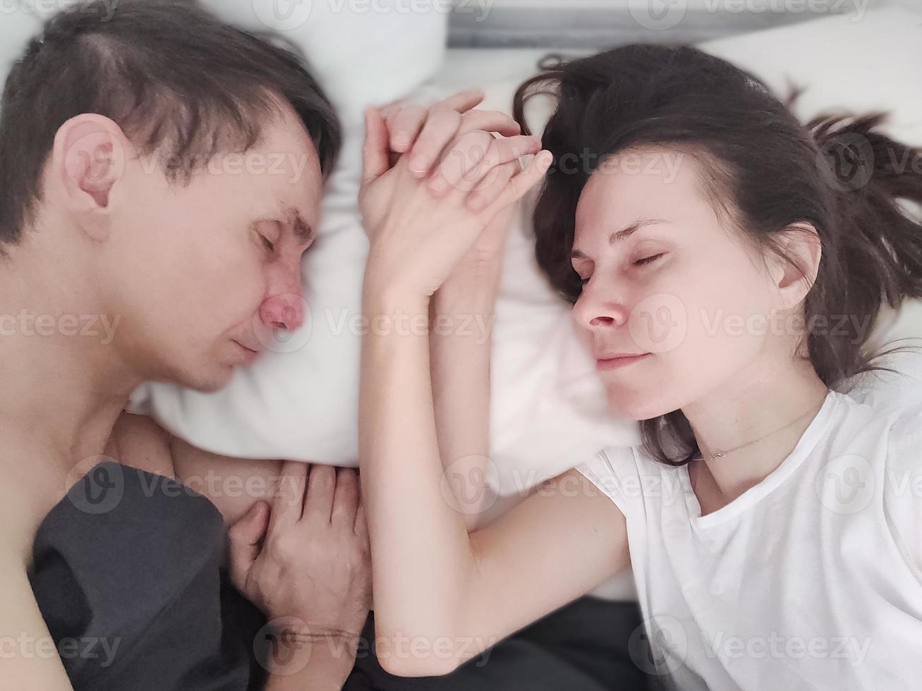 pareja amorosa durmiendo y tomados de la mano foto