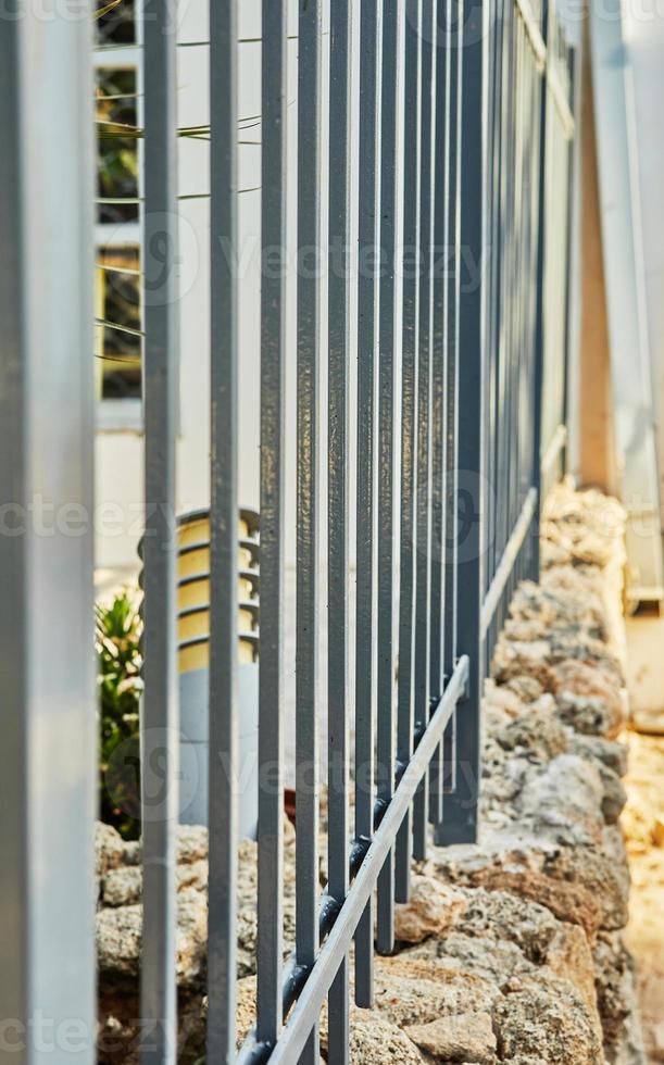 Metal fence on stone fence around the house photo