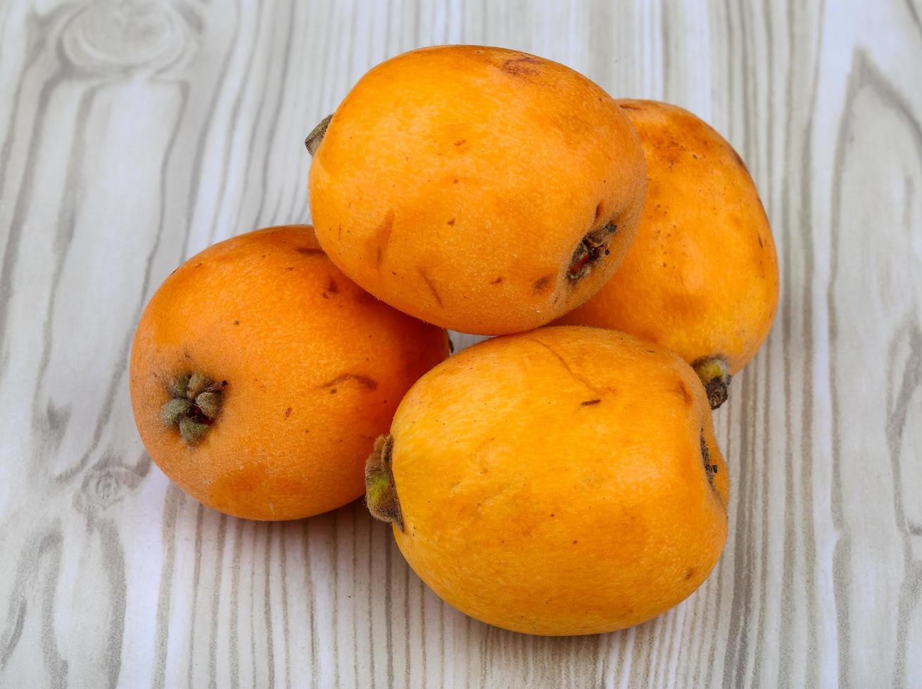 Medlar on wooden background photo