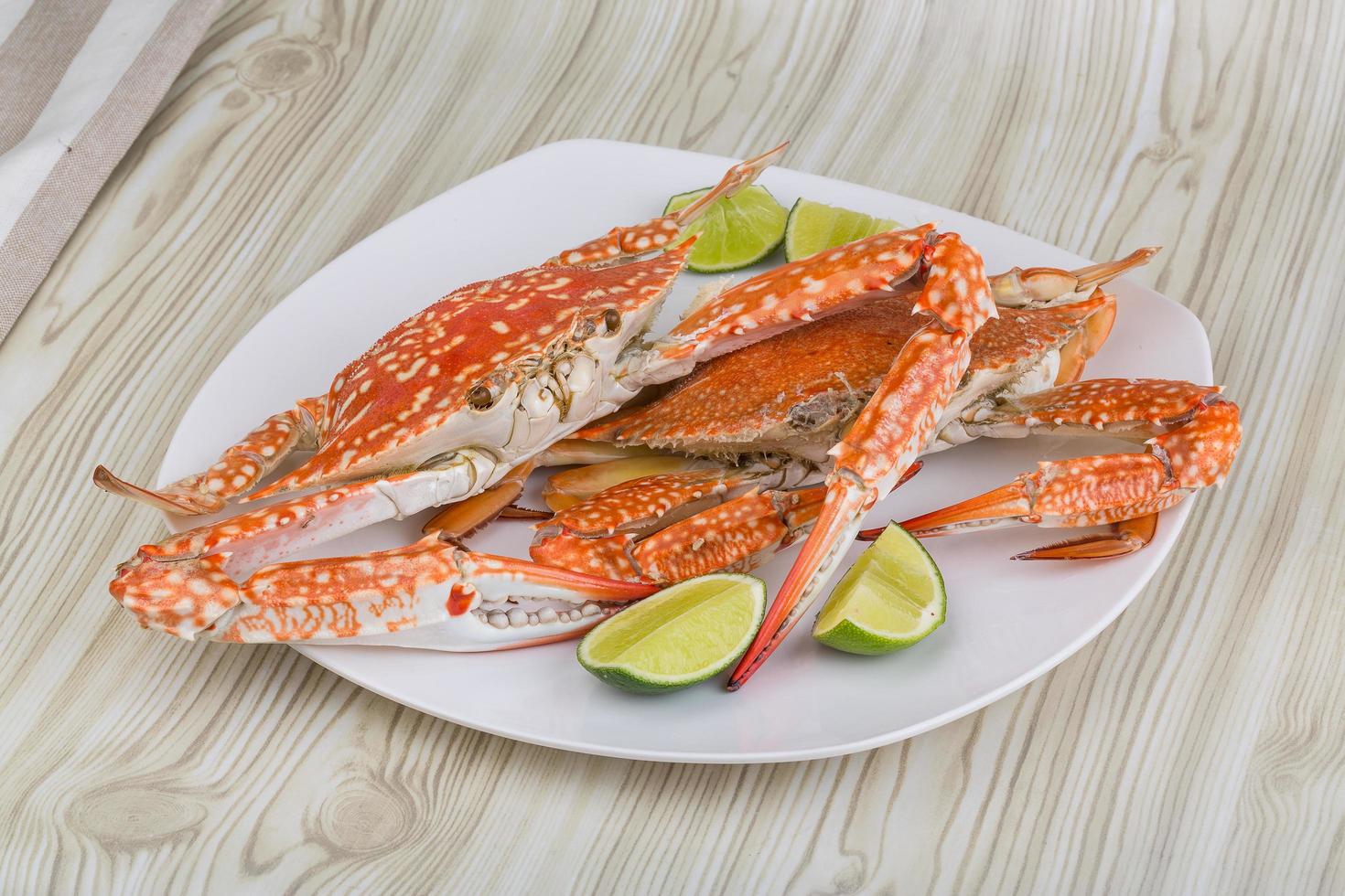 Boiled crabs on the plate and wooden background photo