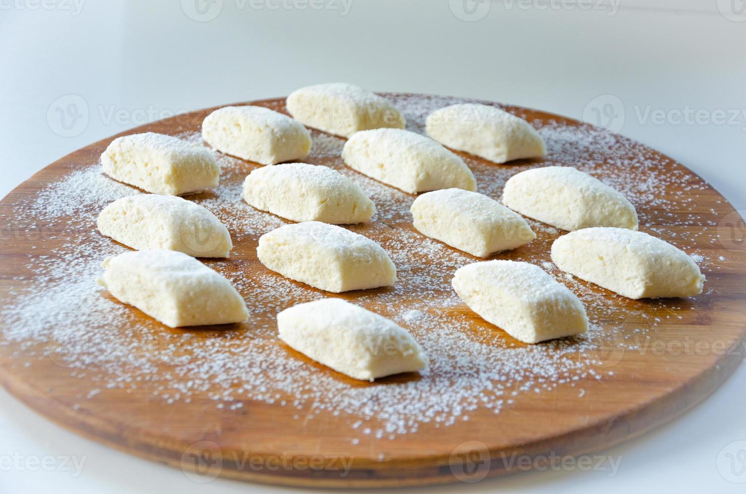 lazy dumplings are laid out on a wooden board on a light background photo