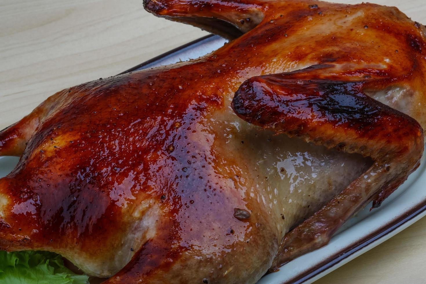 Roasted duck on the plate and wooden background photo
