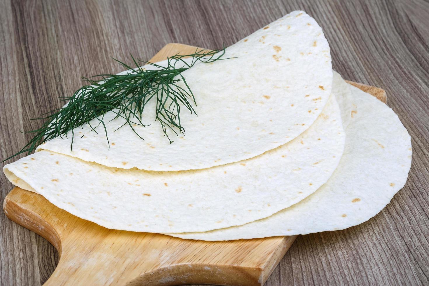 tortillas en tablero de madera y fondo de madera foto