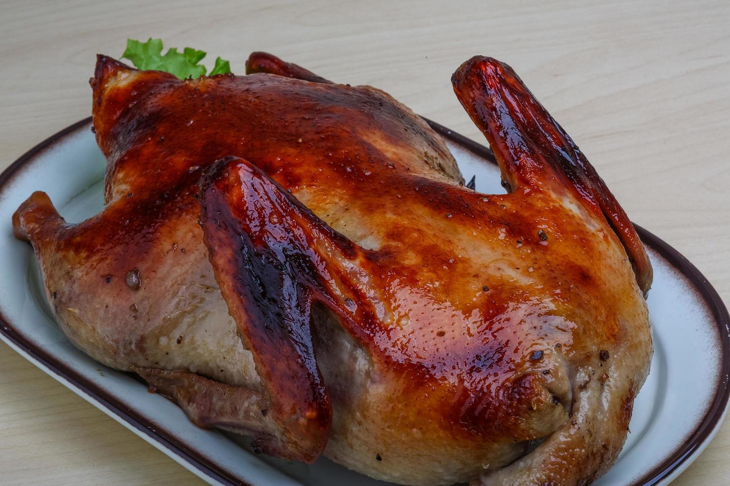 pato asado en el plato y fondo de madera foto