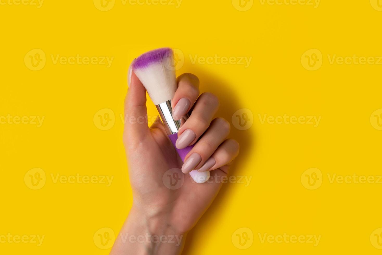 Female hands with a beautiful manicure on a yellow background,top view photo