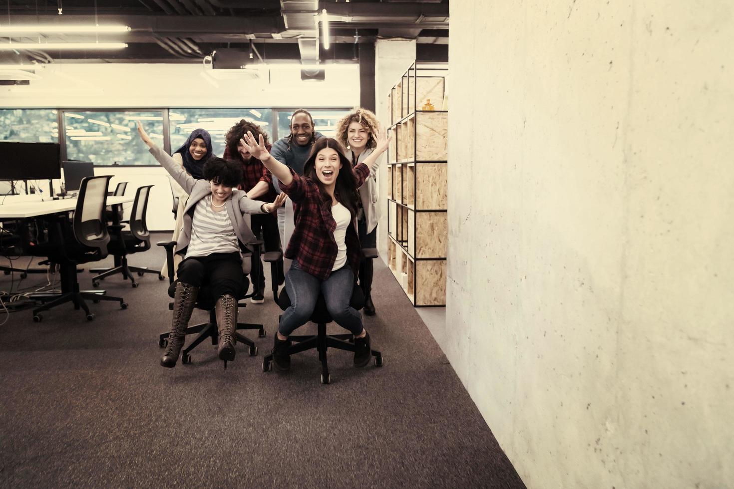 equipo de negocios multiétnico corriendo en sillas de oficina foto