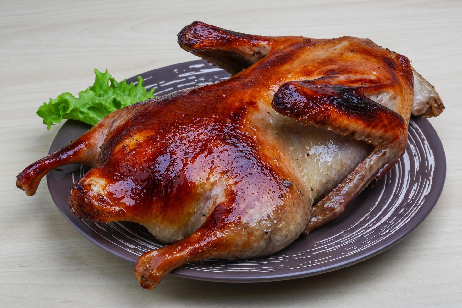 Roasted duck on the plate and wooden background photo