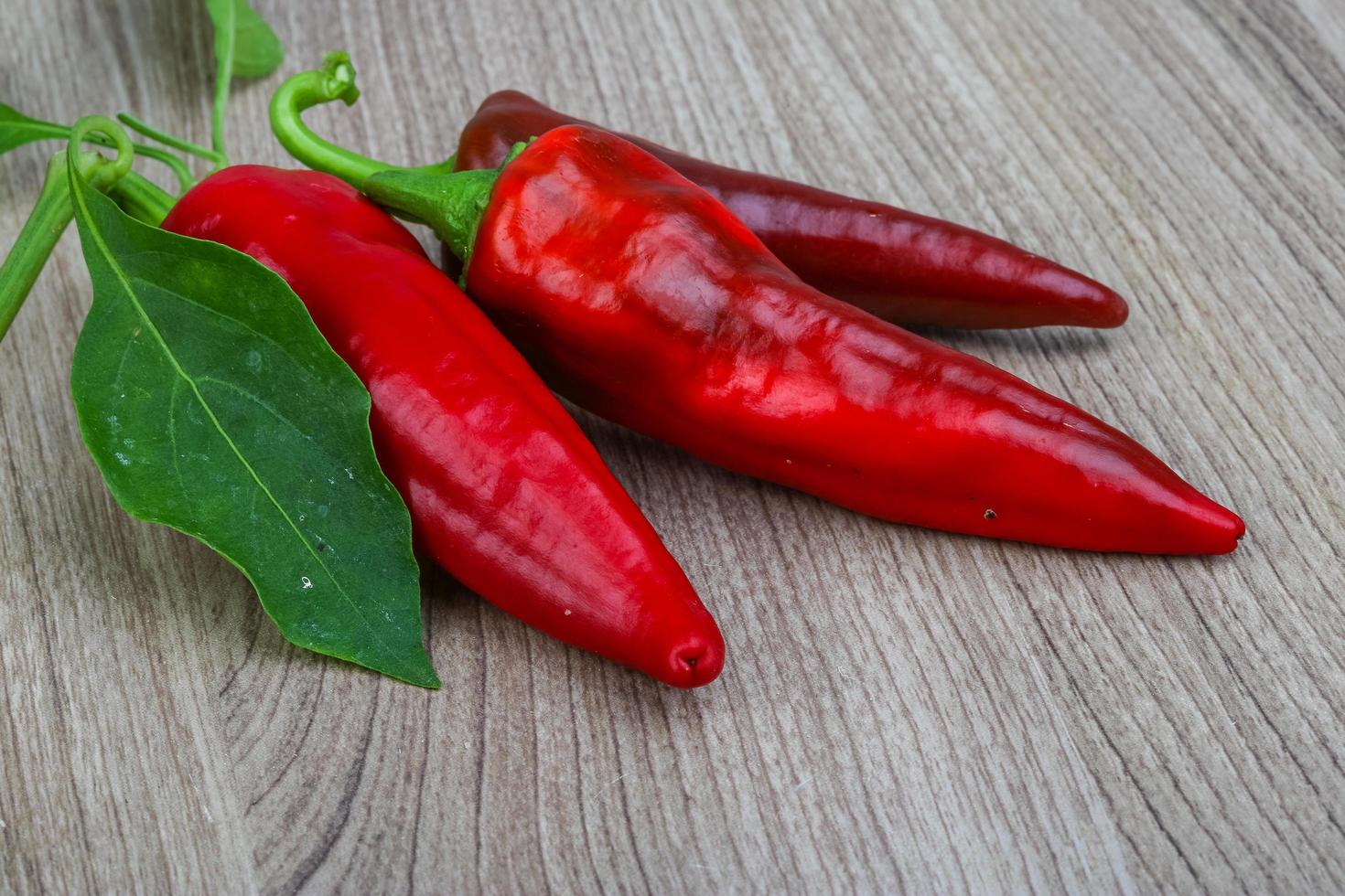 pimientos rojos sobre fondo de madera foto