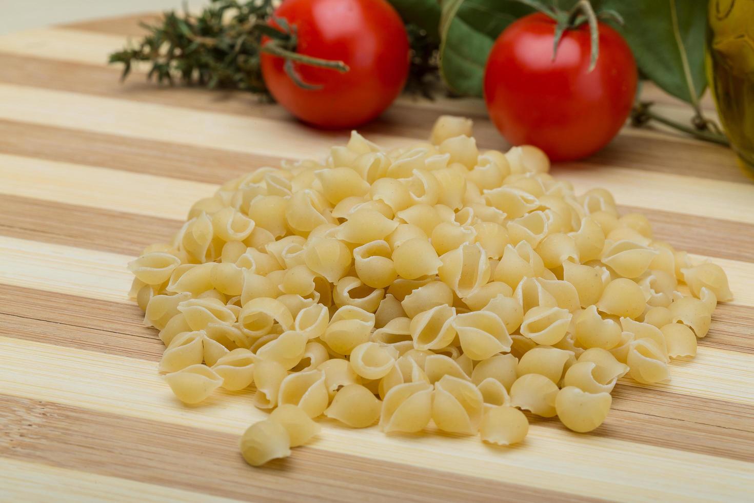 Shell pasta on wooden board photo