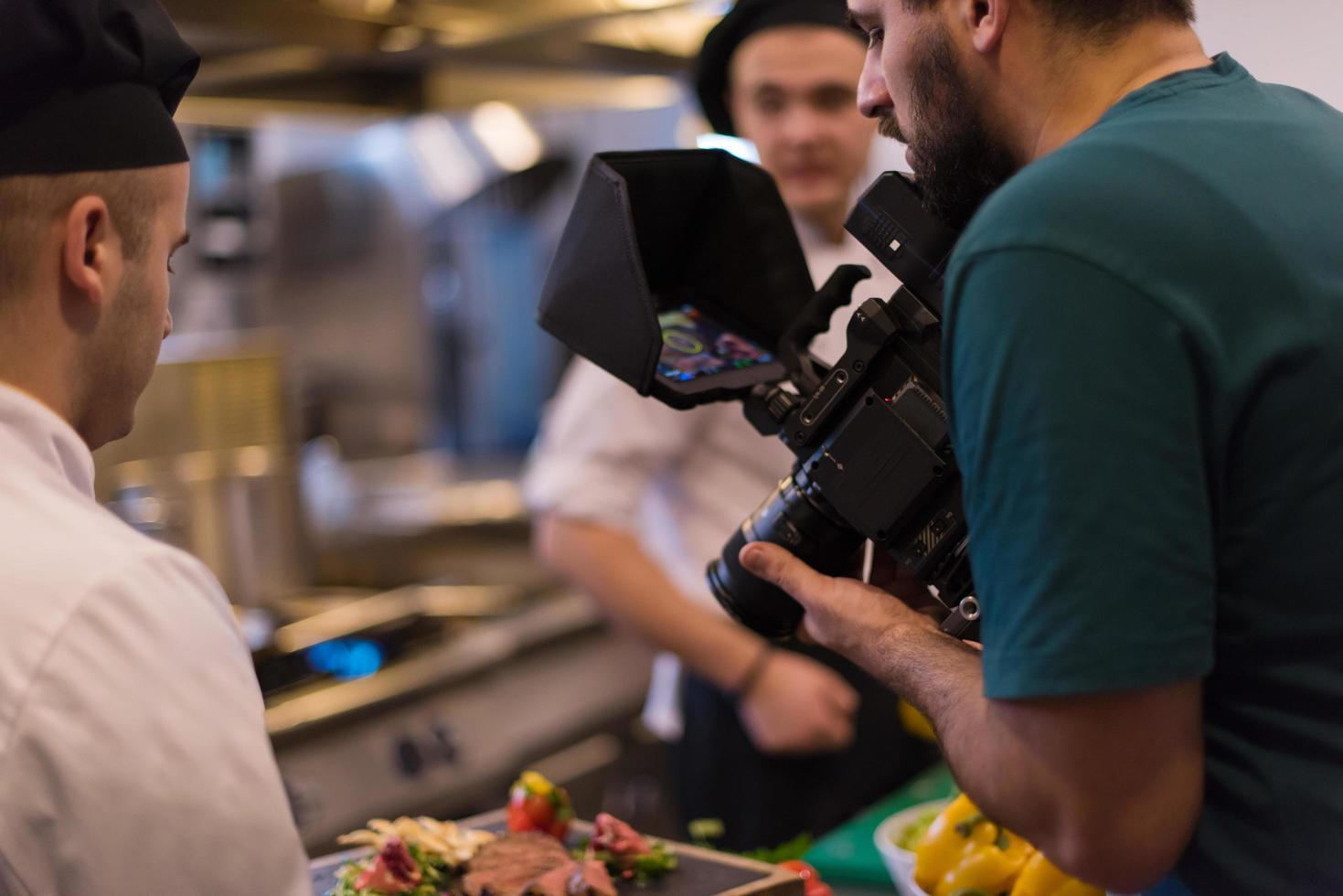 videographer recording while team cooks and chefs preparing meal photo