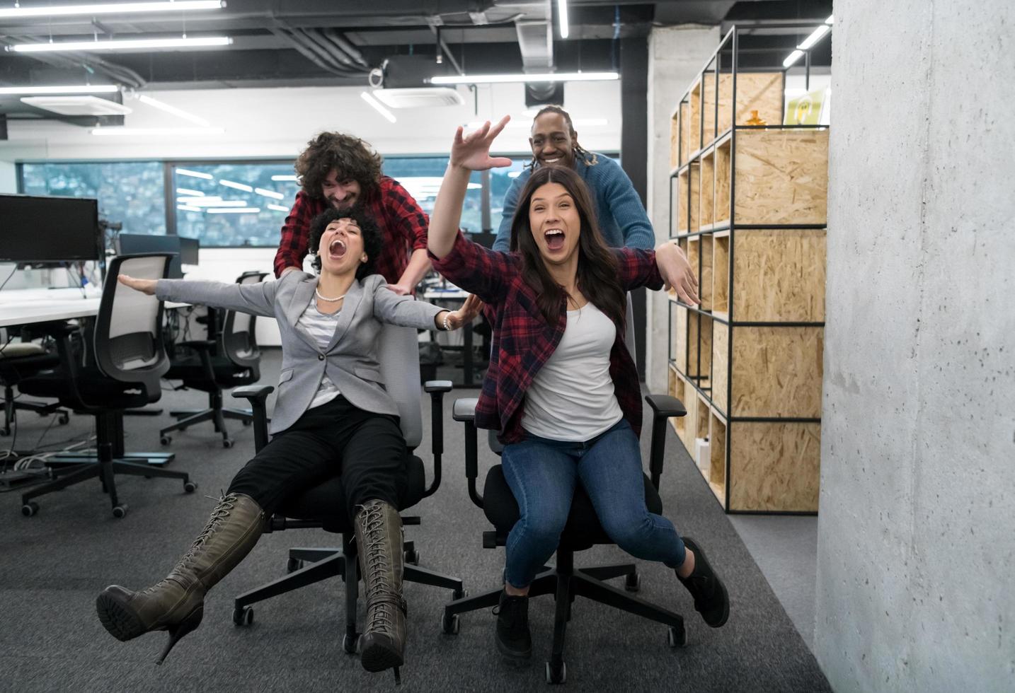 equipo de negocios multiétnico corriendo en sillas de oficina foto