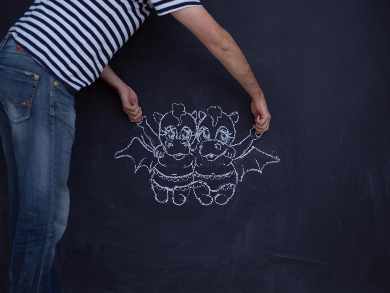 future dad drawing his imaginations on chalk board photo