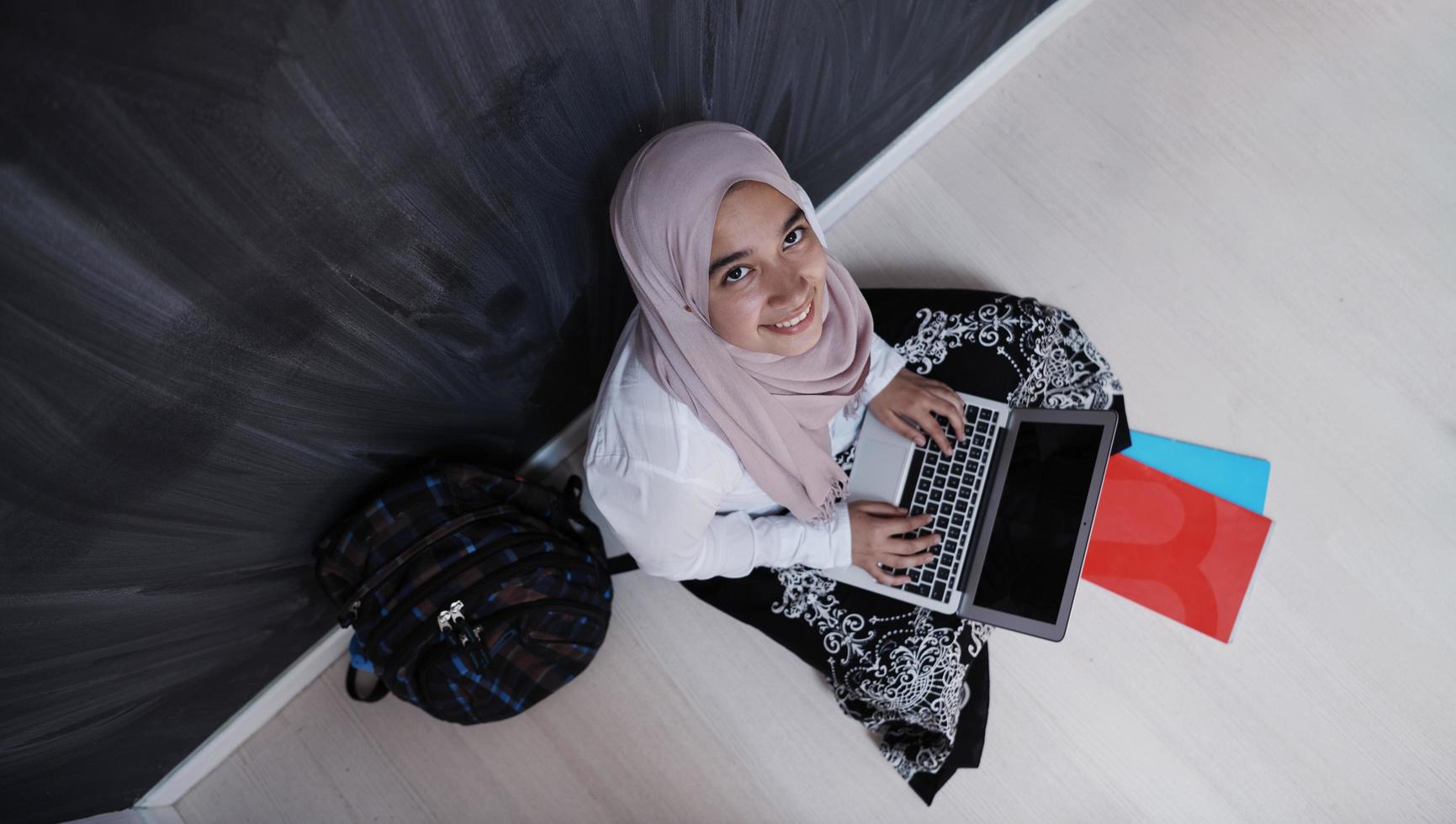 estudiante árabe trabajando en una laptop desde casa foto