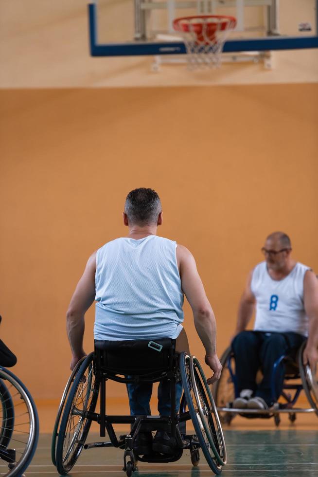 a war invalid in a wheelchair trains with a ball at a basketball club in training with professional sports equipment for the disabled. the concept of sport for people with disabilities photo