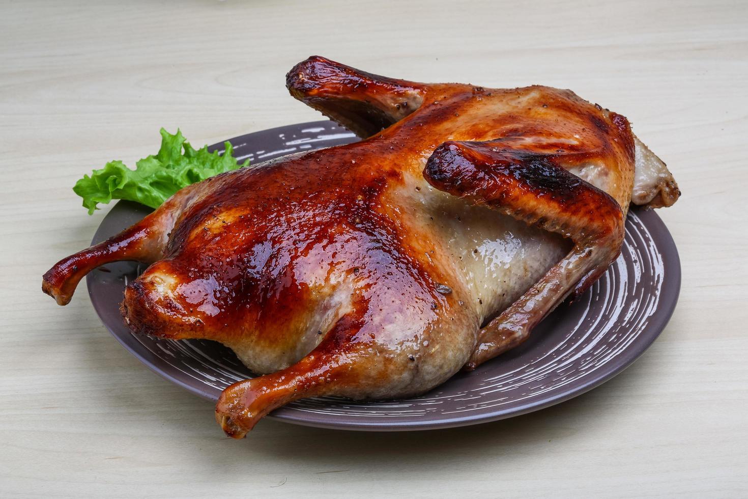 pato asado en el plato y fondo de madera foto