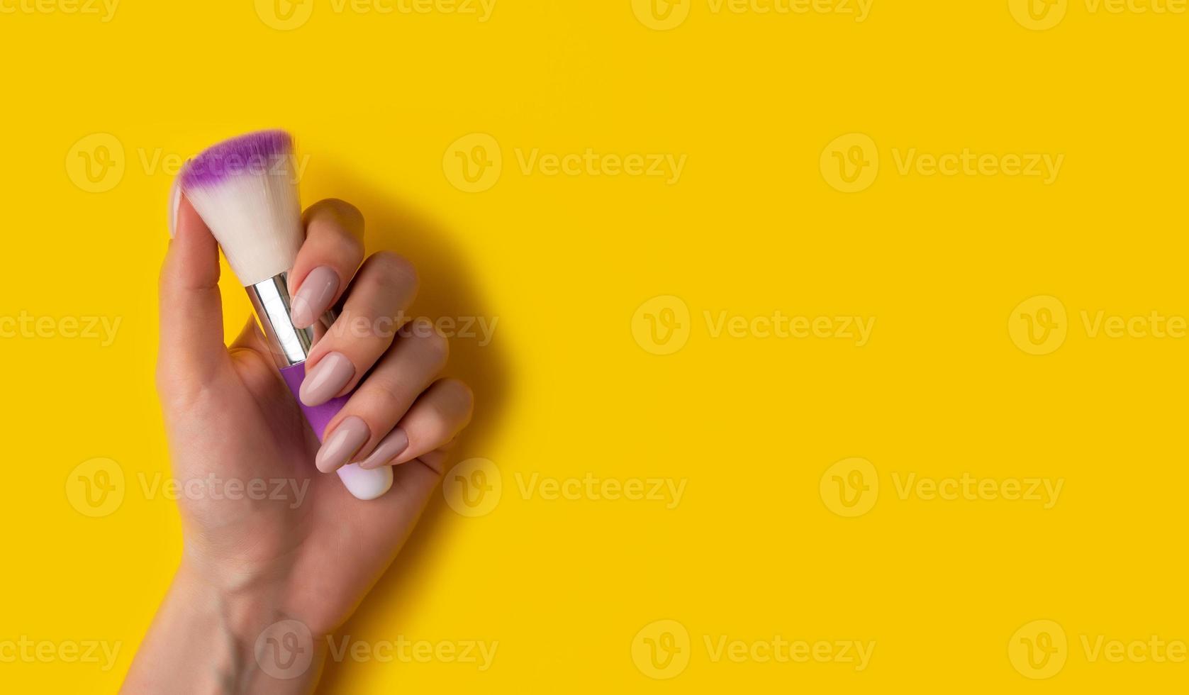 Female hands with a beautiful manicure on a yellow background,top view photo