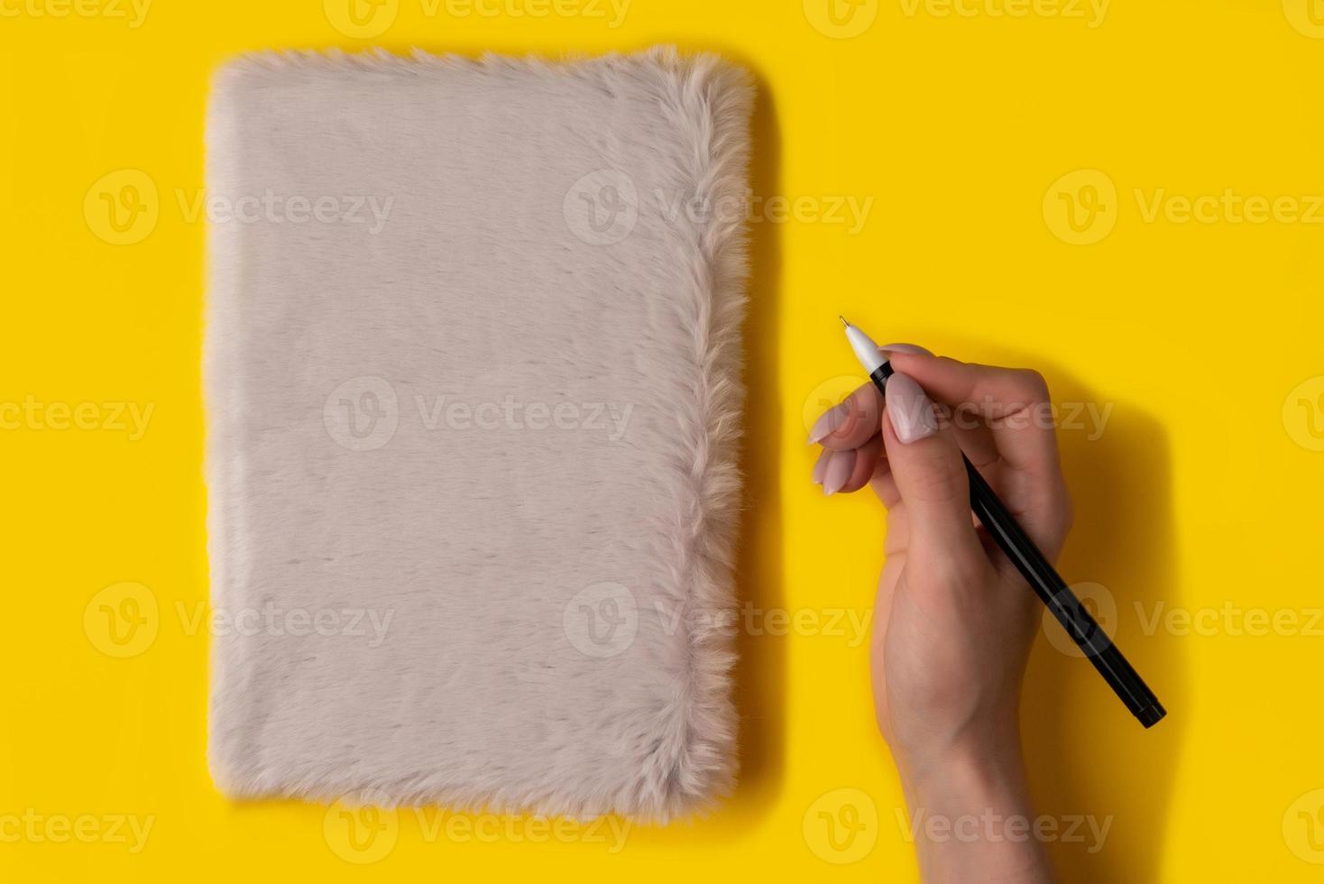 notebook,pen, on yellow background. top view photo