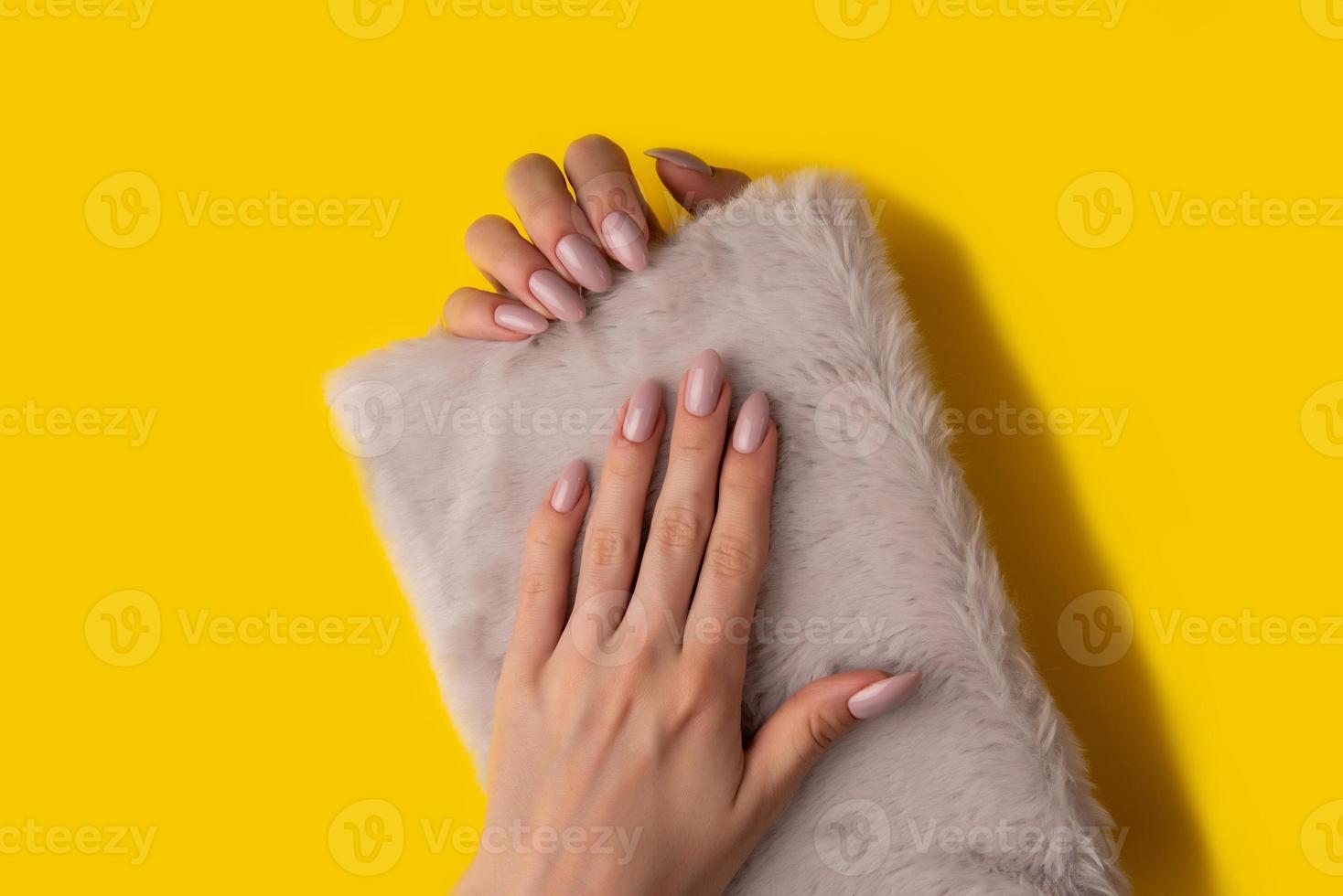 Female hands with a beautiful manicure on a yellow background,top view photo
