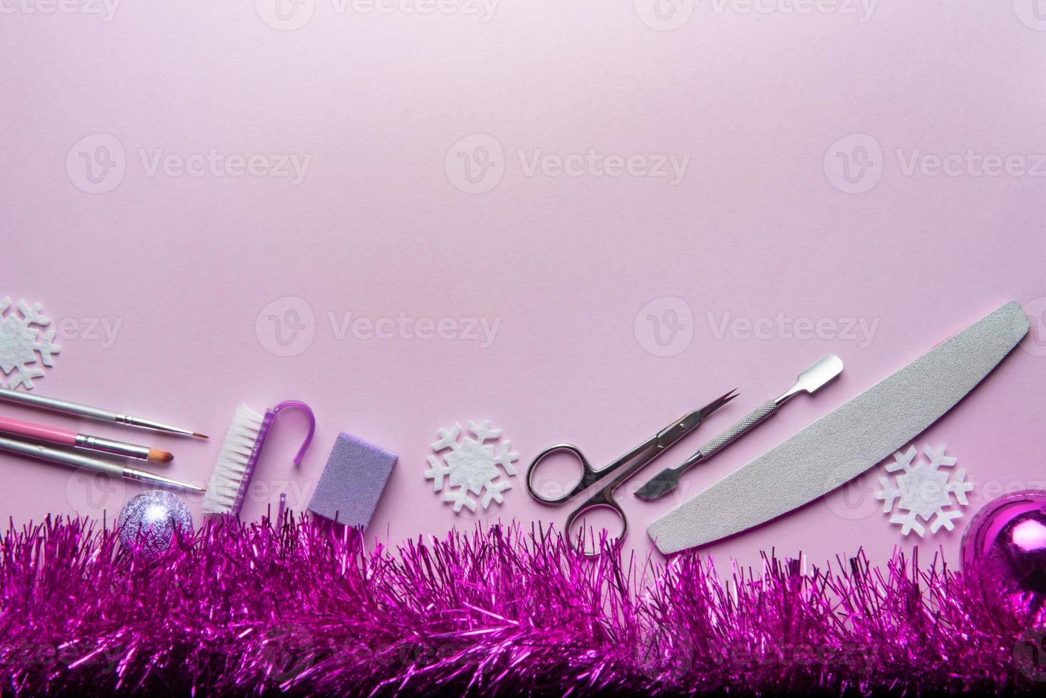vista superior del equipo de manicura y pedicura sobre fondo de navidad rosa foto