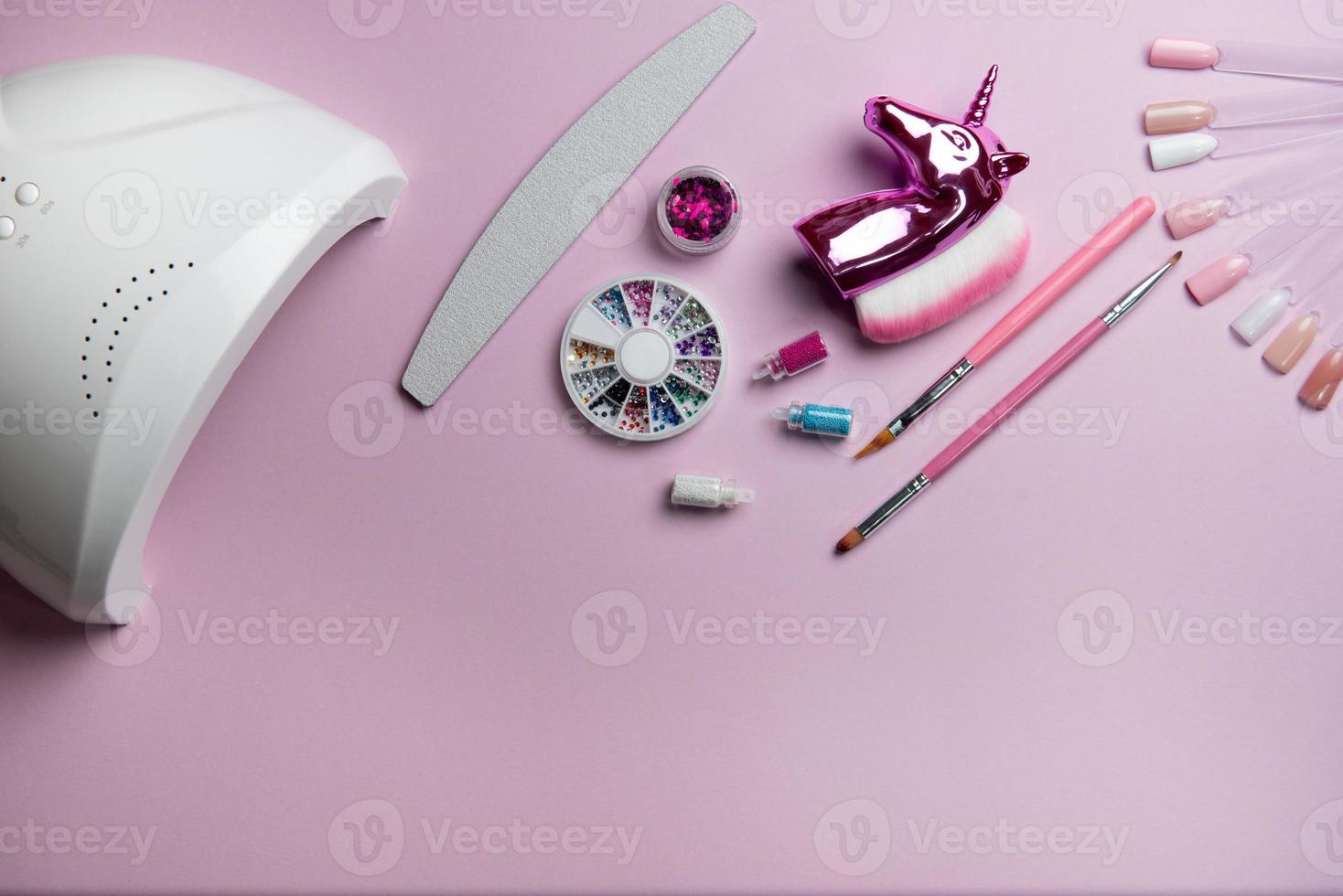 Top view of manicure and pedicure equipment on pink background photo