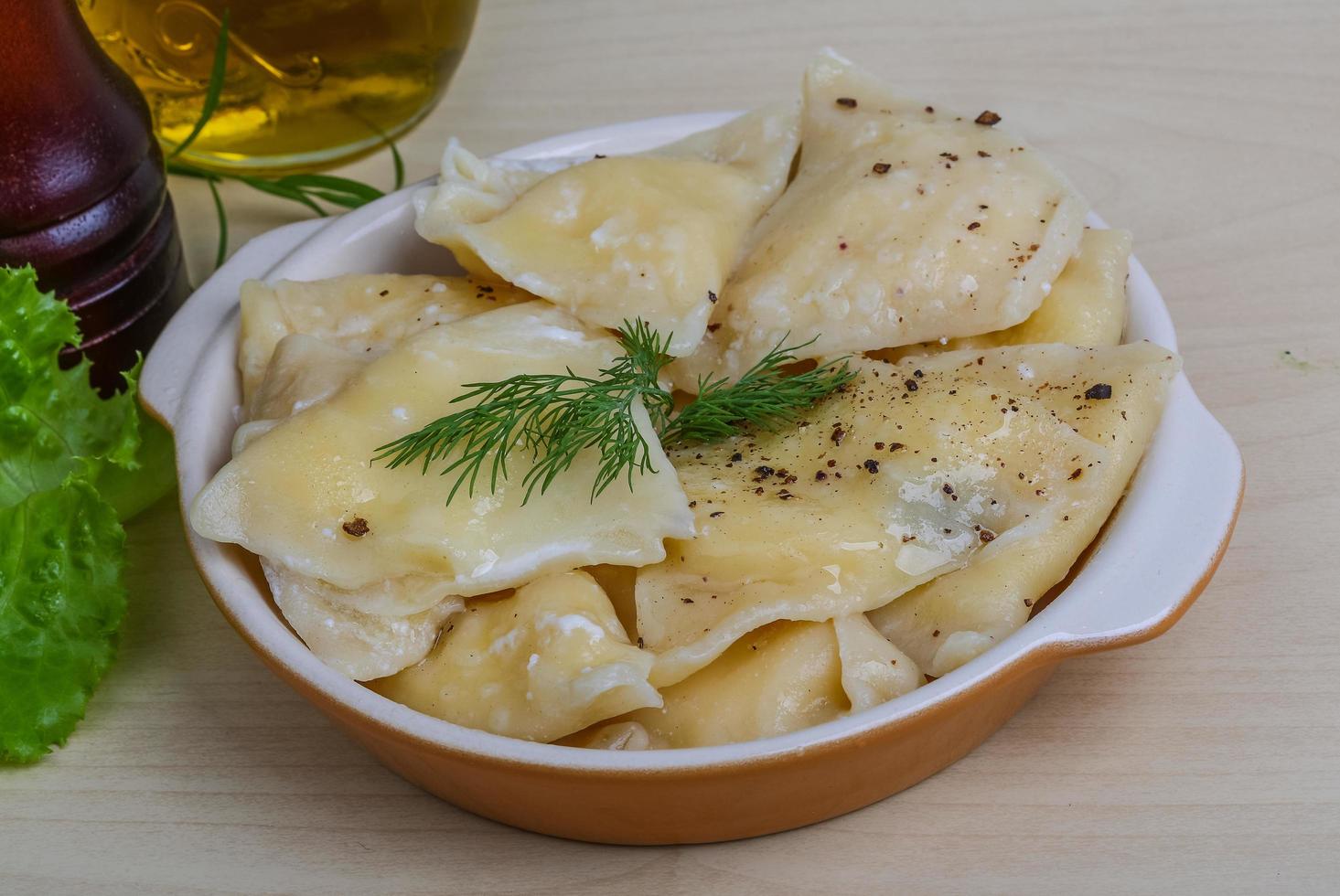 Vareniki in a bowl on wooden background photo