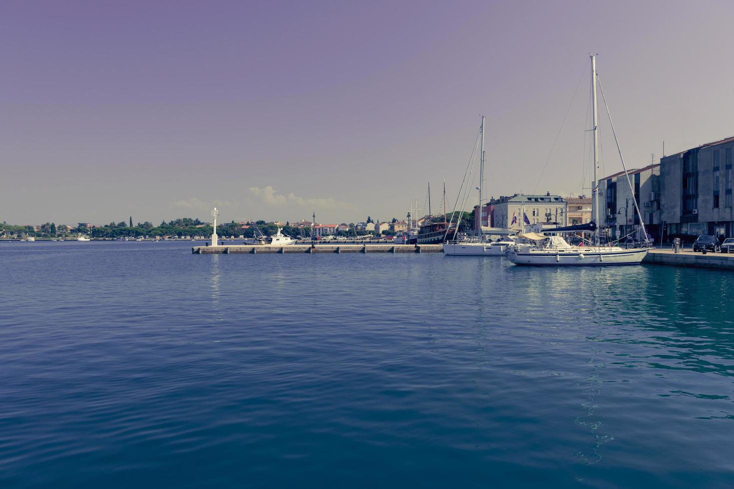 A photograph of a ship and a luxury yacht anchored in port. Beautiful photo of a Mediterranean port