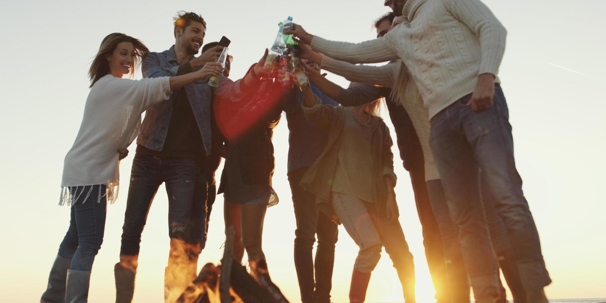 Friends on beach party drinking beer and having fun photo