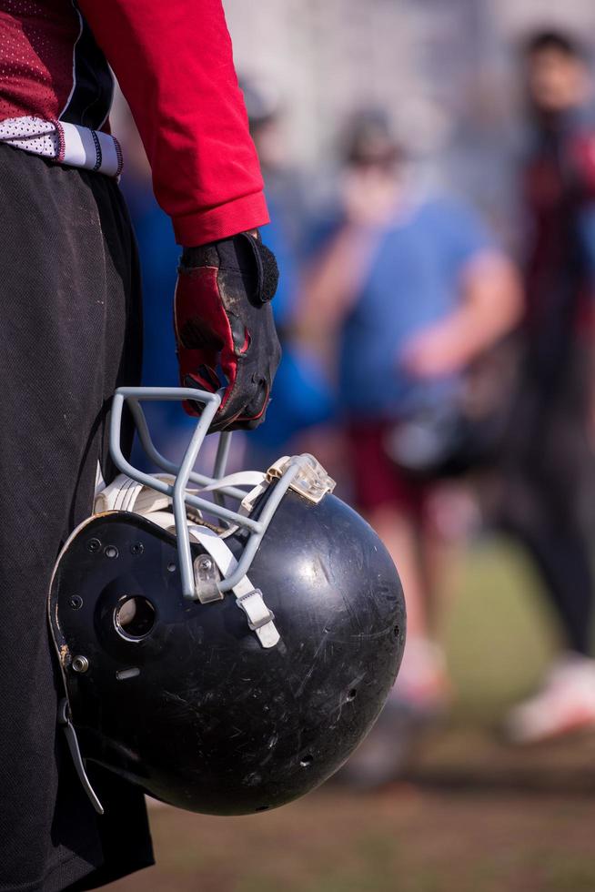 American football player holding helmet photo