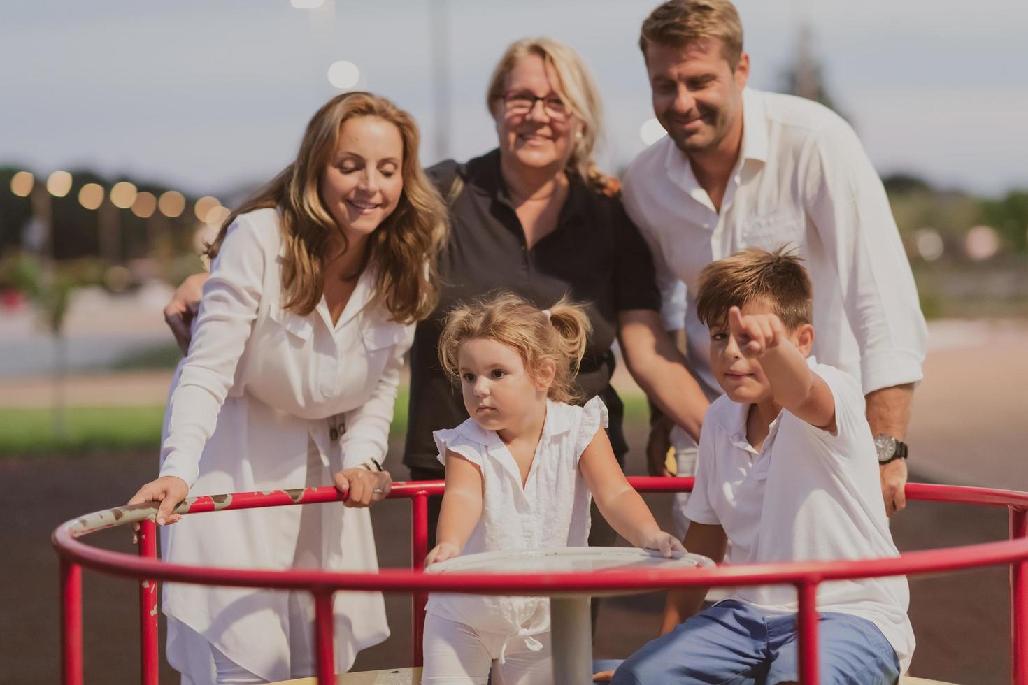 An elderly couple in casual clothes with their children and grandmother spend time together in the park on vacation. Family time. Selective focus photo