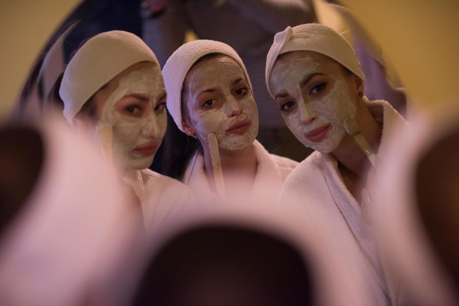 women putting face masks in the bathroom photo