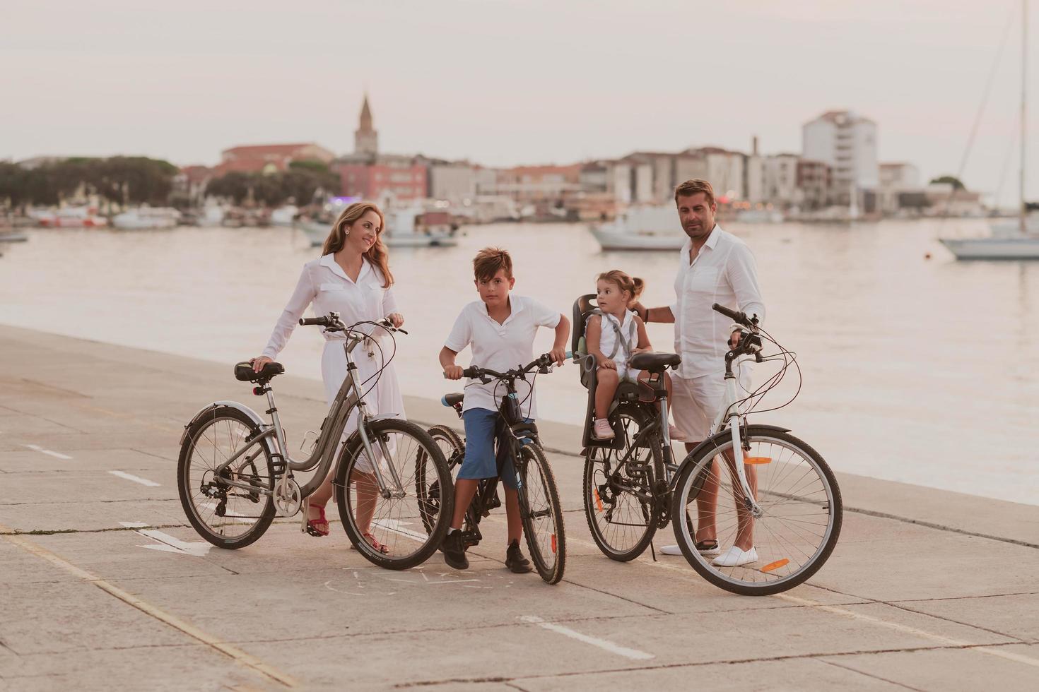 The happy family enjoys a beautiful morning by the sea riding a bike together and spending time together. The concept of a happy family photo