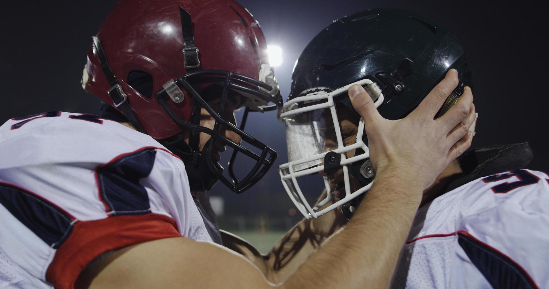 American football players knocking with helmets and having fun photo