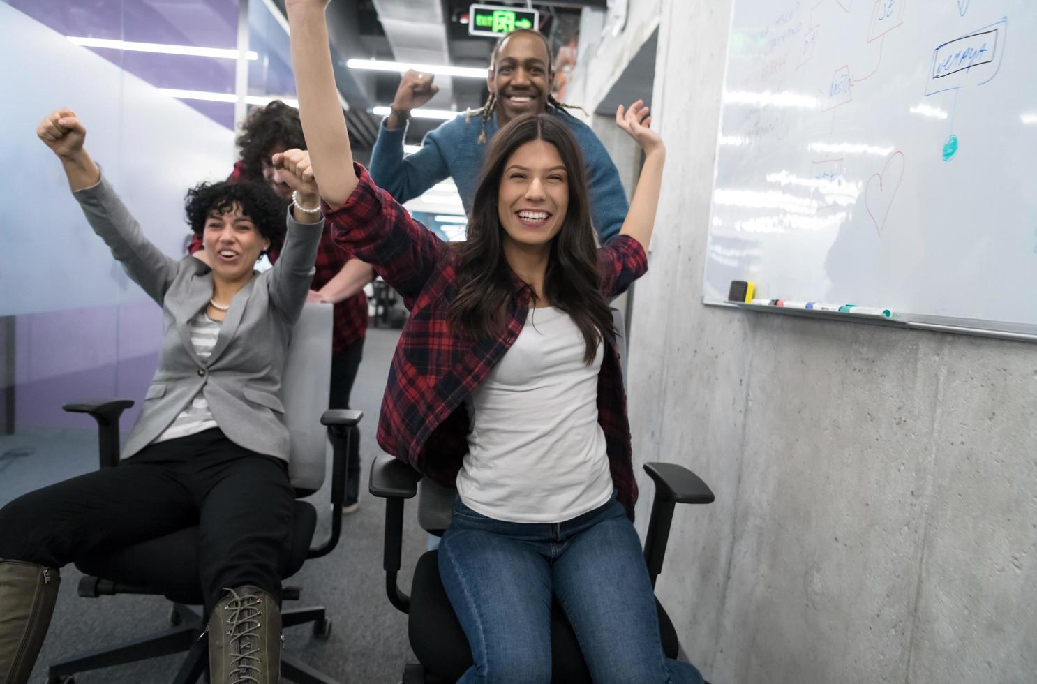 multiethnics business team racing on office chairs photo