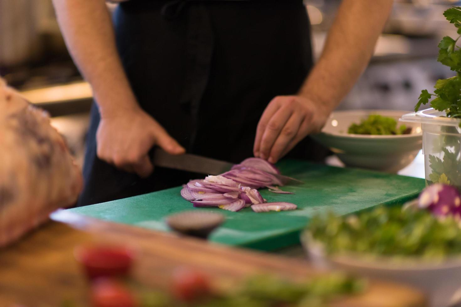 Chef  hands cutting the onion with knife photo