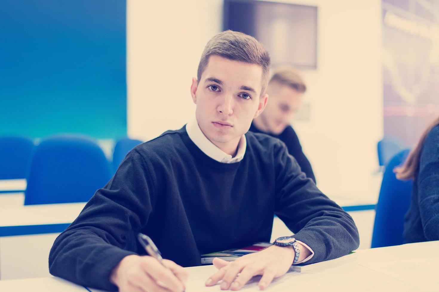 male student writing notes photo