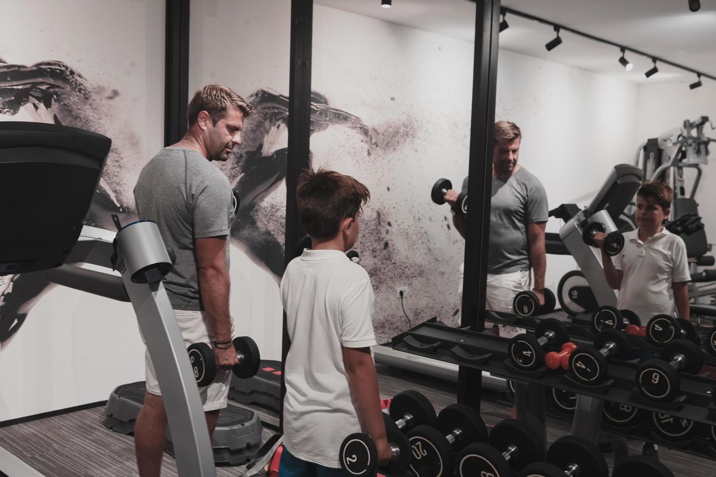 padre e hijo entrenan juntos en el gimnasio de casa. el concepto de vida sana. enfoque selectivo foto