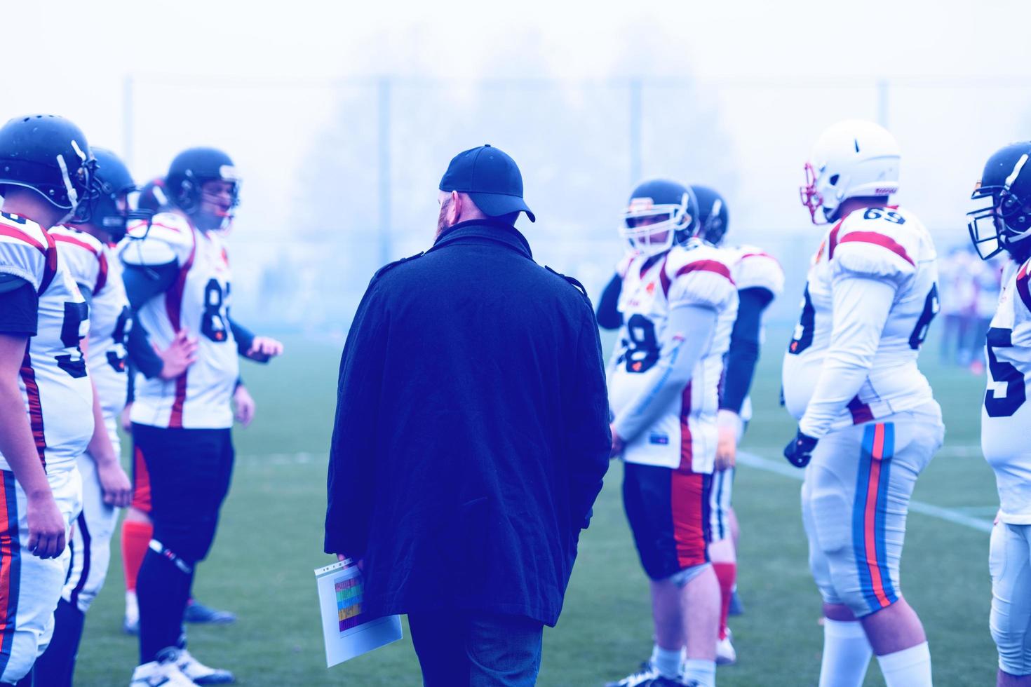 american football players discussing strategy with coach photo