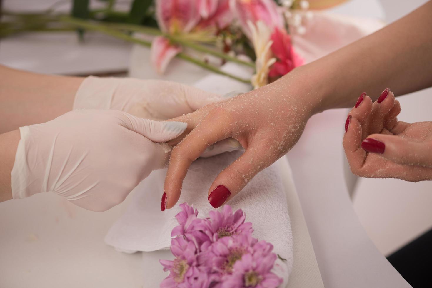 manos de mujer recibiendo una manicura foto