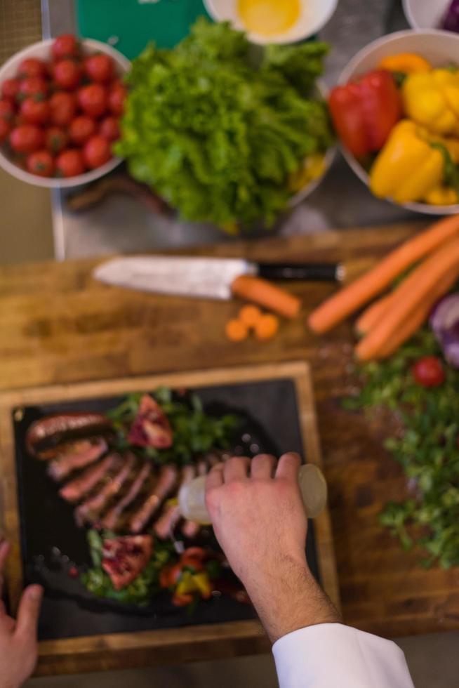 top view of Chef finishing steak meat plate photo
