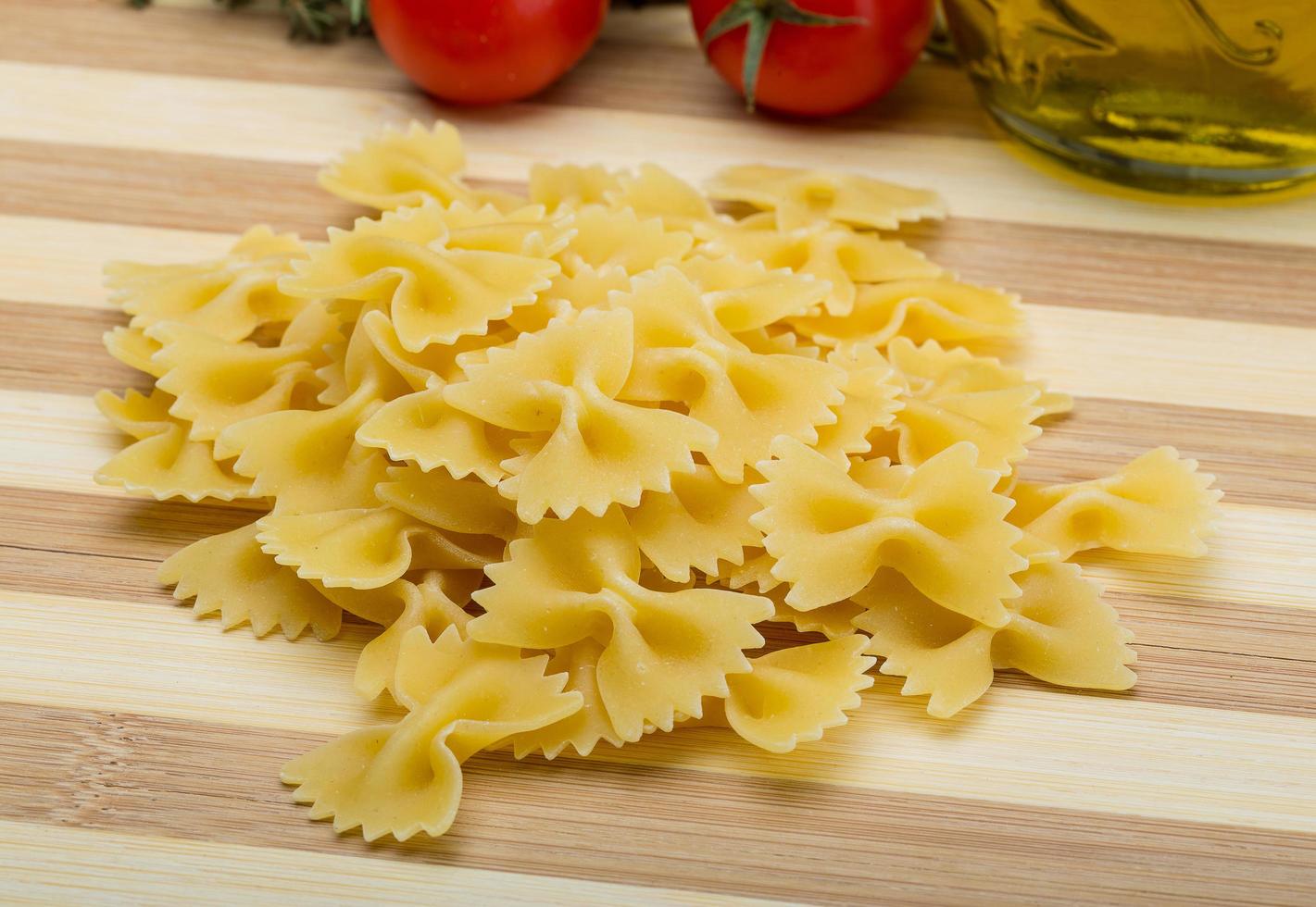 Raw farfalle on wooden background photo