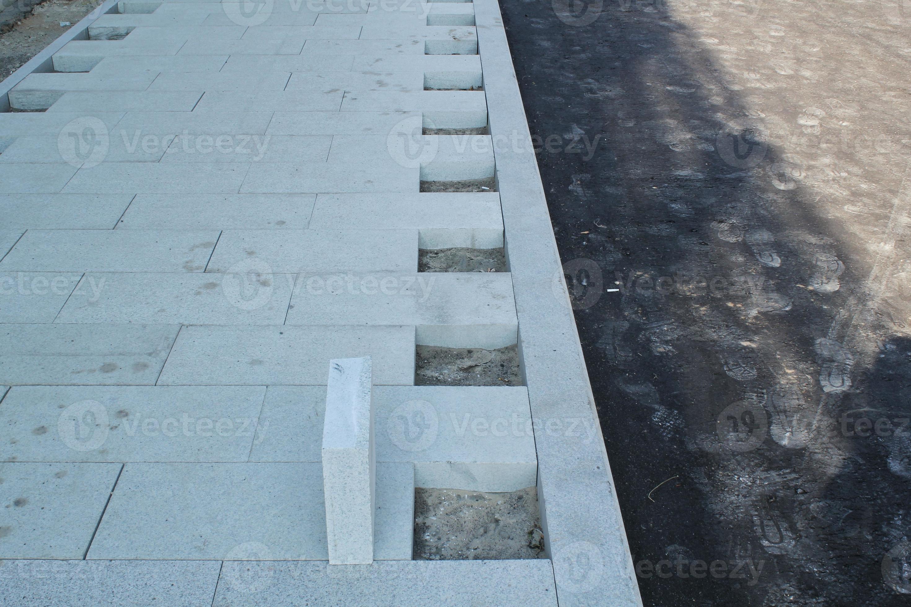 Laying outdoor bricks concrete grey paving slabs on the street. Urban