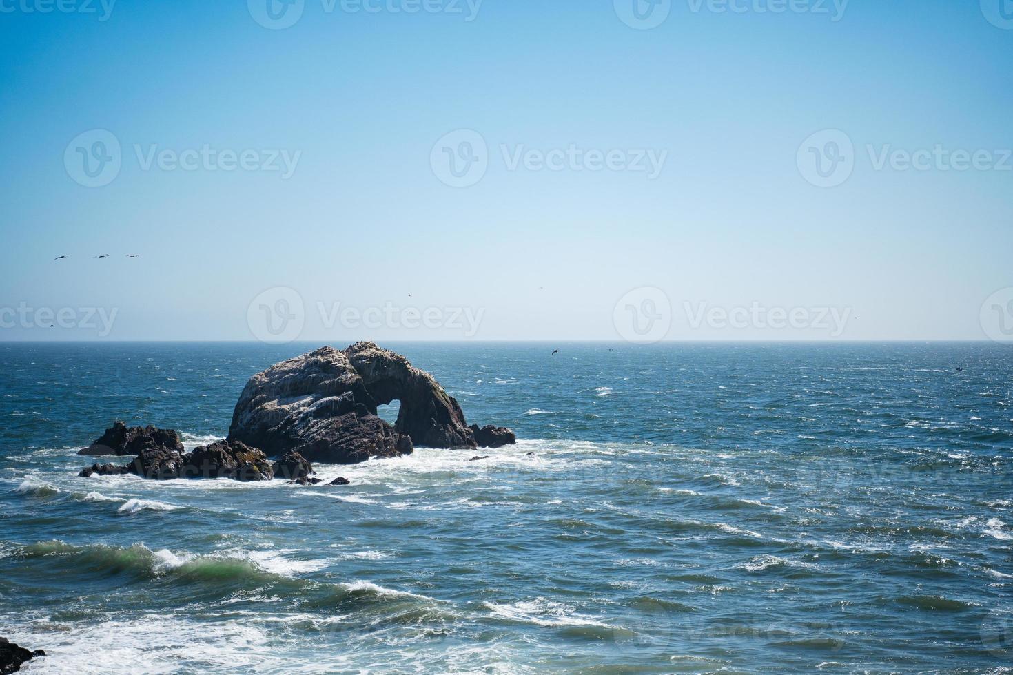 Heart shaped rock in ocean photo