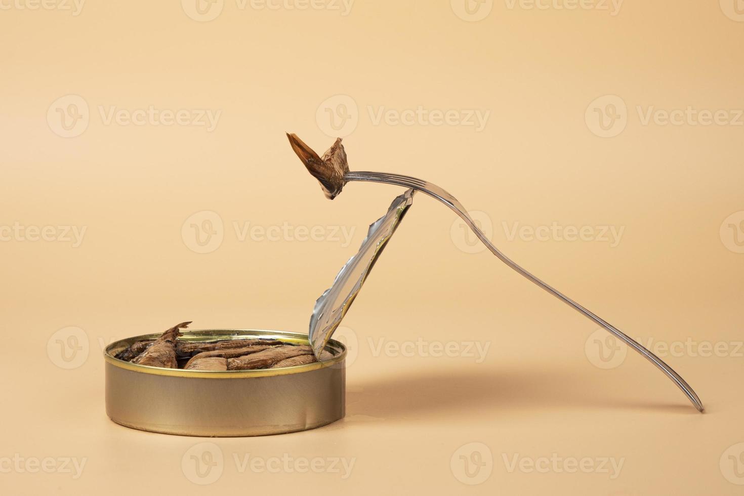 sprat in oil on a fork closeup,small fish delicacie photo