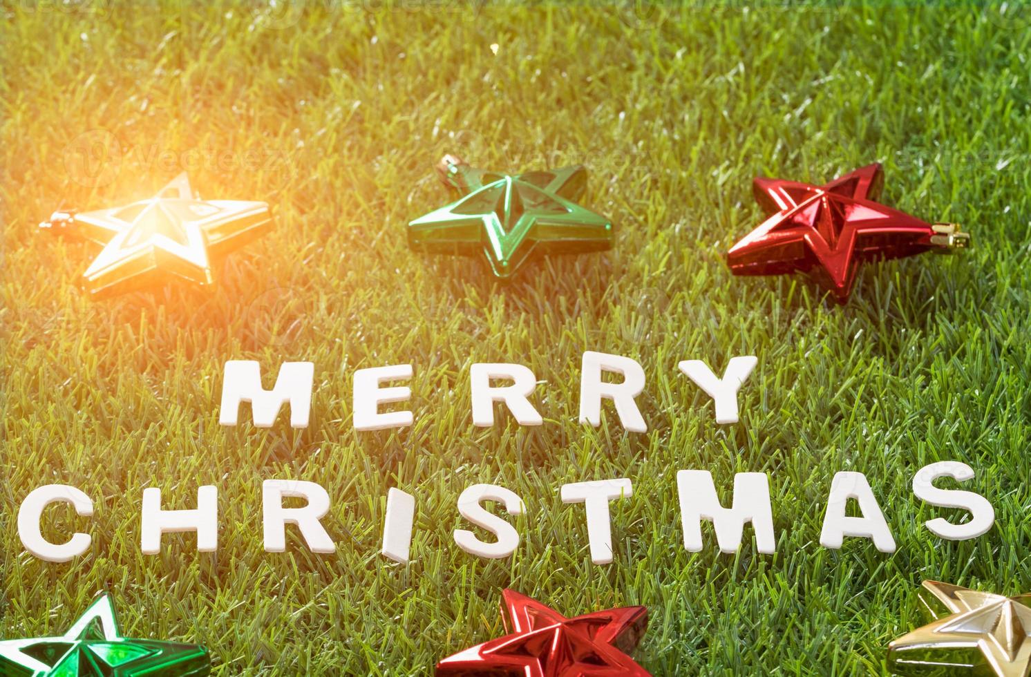 Top view Christmas alphabet and decoration on green grass photo