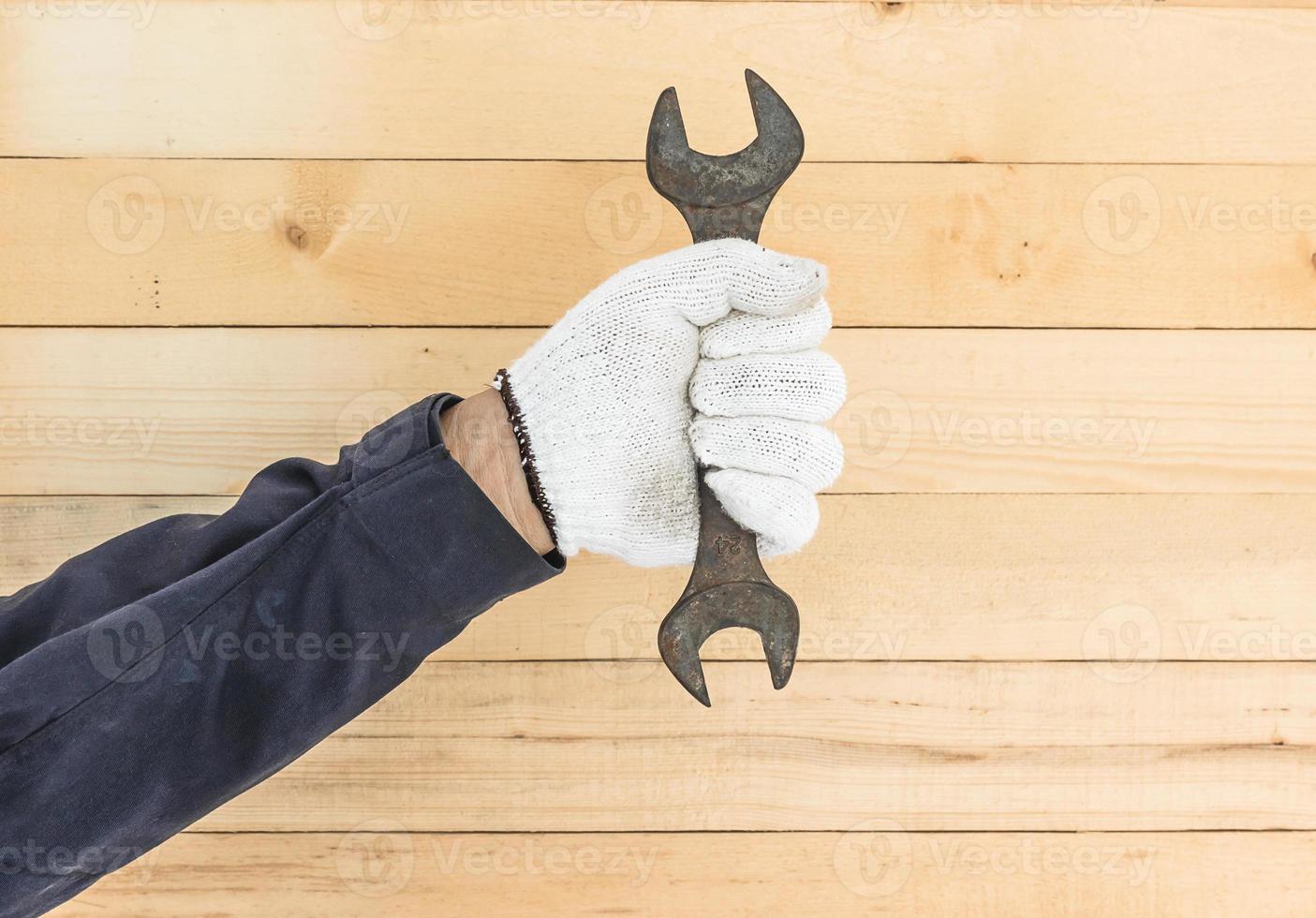 Hand in glove holding spanner photo