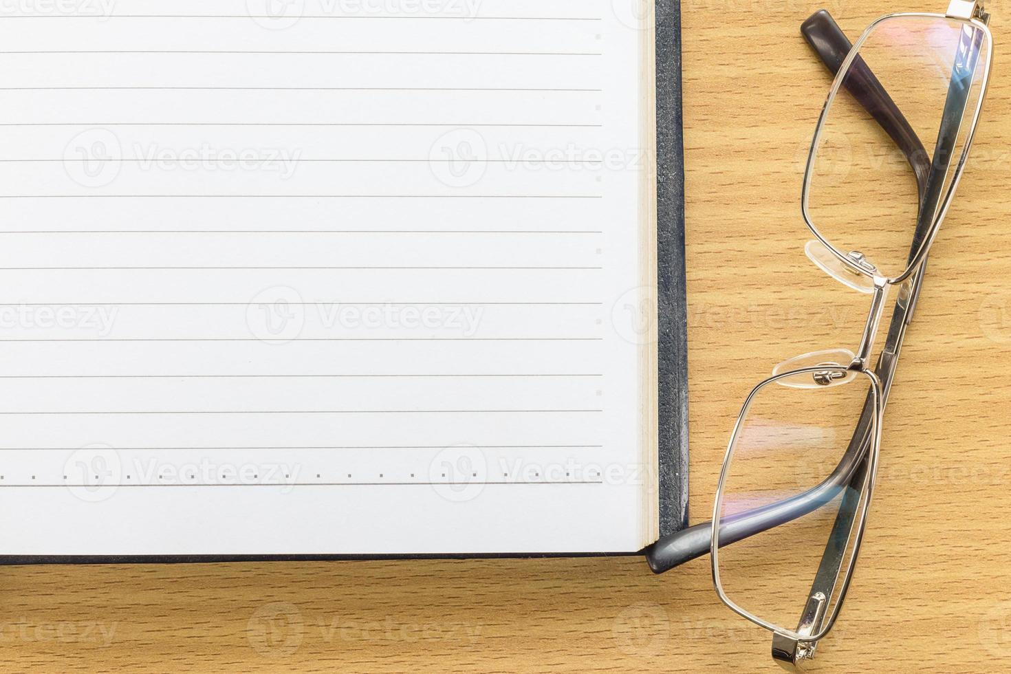 Notebook open blank page and Eyeglasses photo